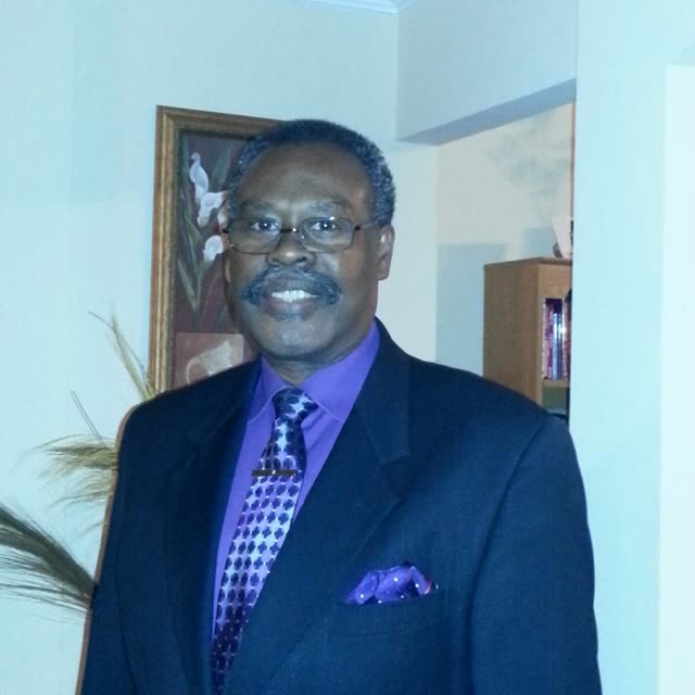A man in a suit and a purple tie.