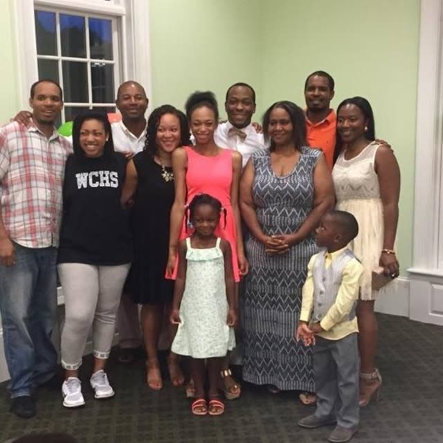 A family group with children poses in a living room.
