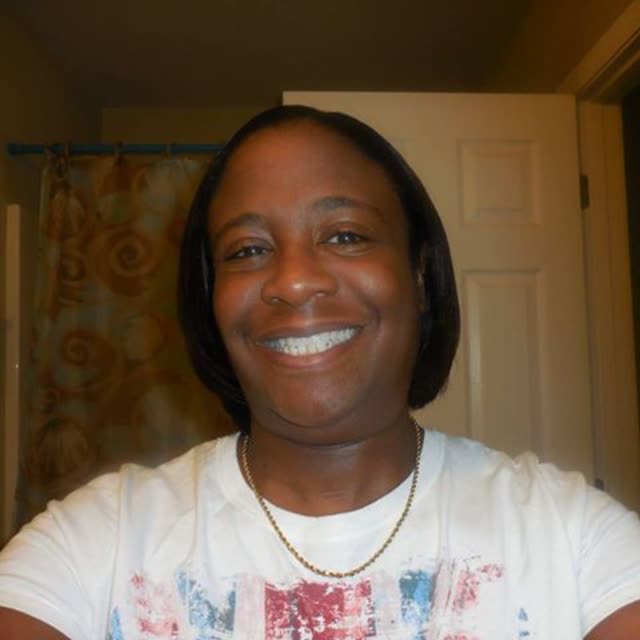 A smiling woman in a white top.