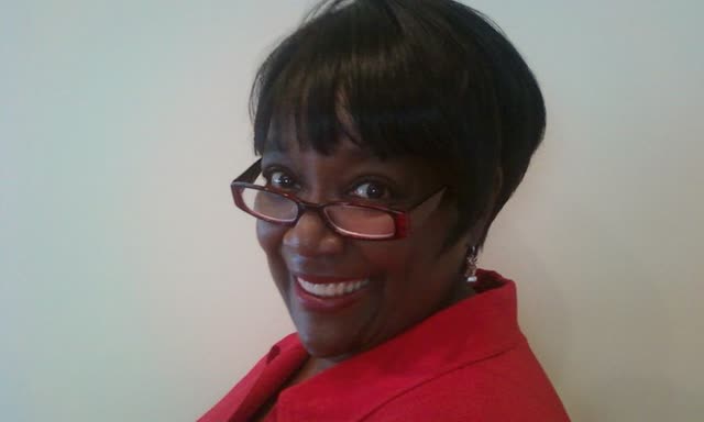 A smiling woman in a red top.