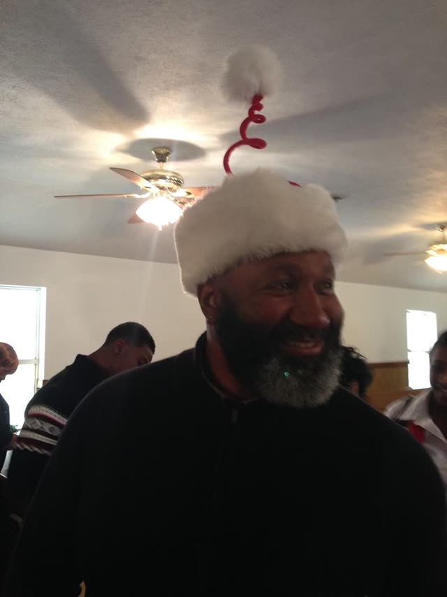 A smiling man in a white knit cap and a dark sweater.